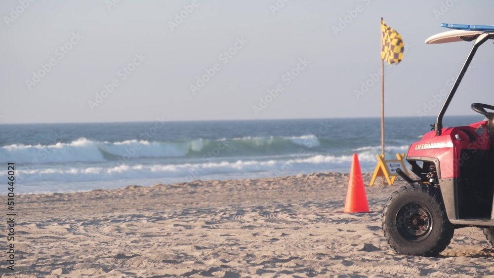 Lifeguard red pickup truck, life guard auto on sand, California ocean beach USA. Rescue pick up car on coast for surfing safety, lifesavers 911 vehicle and sea waves of Mission beach near Los Angeles.