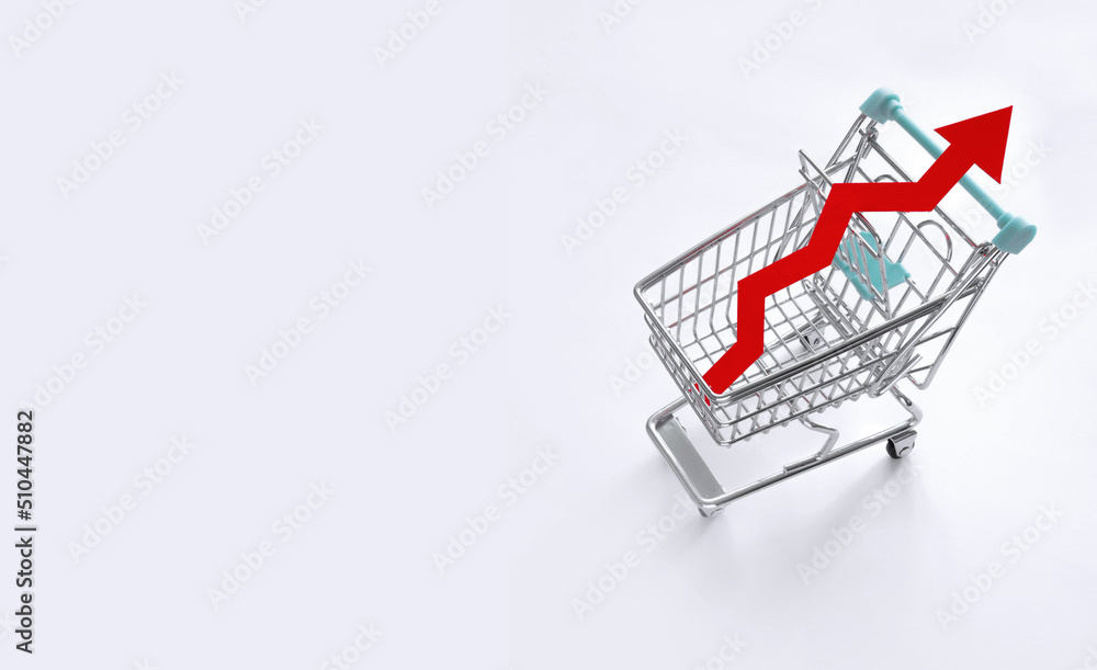 Symbolic Representation of Inflation, Rising Prices and the High Cost of Living. Red Rising Arrow in a Shopping Cart. Shopping Trolley with Red Arrow Symbolizing a Price Increaseon a White Background.