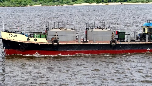 River navigation. A pushboat, a tugboat goes along the Volga River in summer in sunny weather. High quality FullHD footage photo