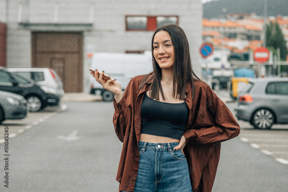 Obraz premium young girl on the street with mobile phone