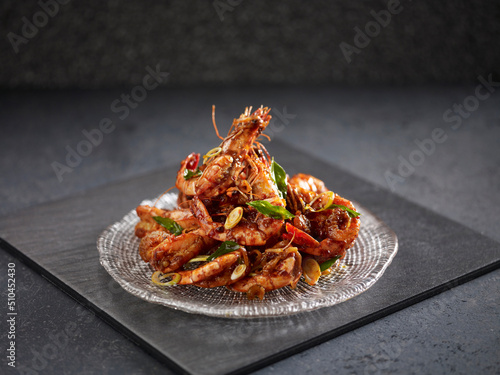Stir-fried Tiger Prawn with Spicy Garlic sauce served in a dish isolated on cutting board side view on dark background photo