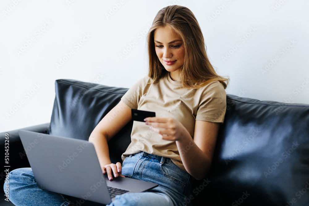 Young pretty woman working with laptop and credit card at home Young pretty woman working with laptop and credit card at home