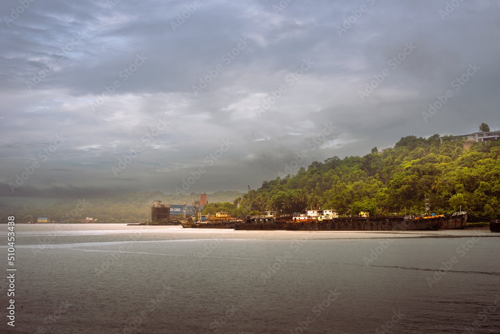 Beautiful monsoon landscape in Goa India from the San Jacinto island with ship building activities and barges docked on the port. - obrazy, fototapety, plakaty 