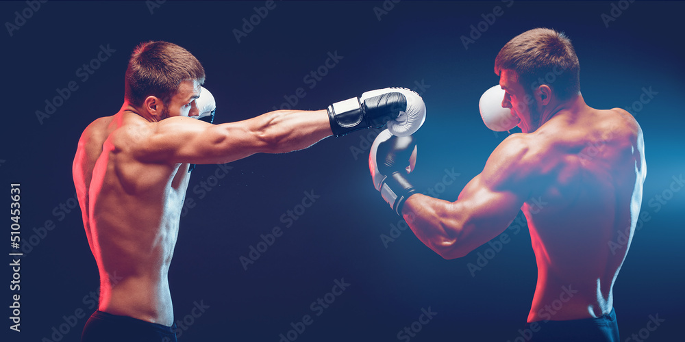 Two boxers boxing on dark background with copy space. Sport concept
