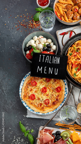 Italian food assortment on dark background.