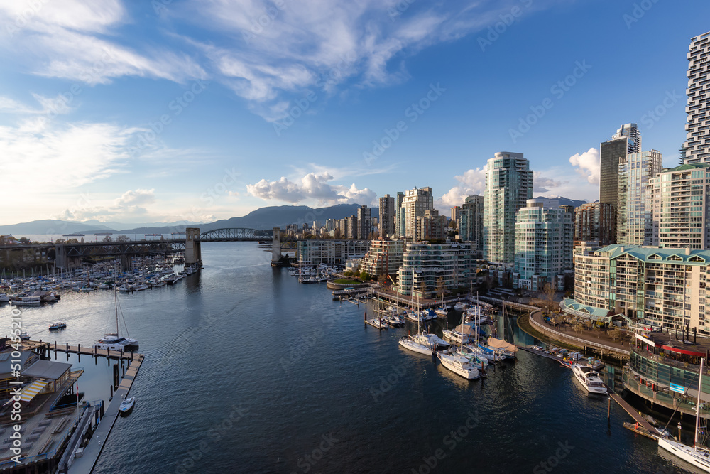 Aerial View of Granville Island in False Creek with modern city skyline and mountains in background. Downtown Vancouver, British Columbia, Canada.