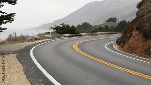 Pacific coast highway 1, Cabrillo road along ocean, foggy California, Big Sur, USA. Coastal road trip, traveling on car by sea. Cloudy misty weather. Yellow dividing line, asphalt. Turn of serpentine.