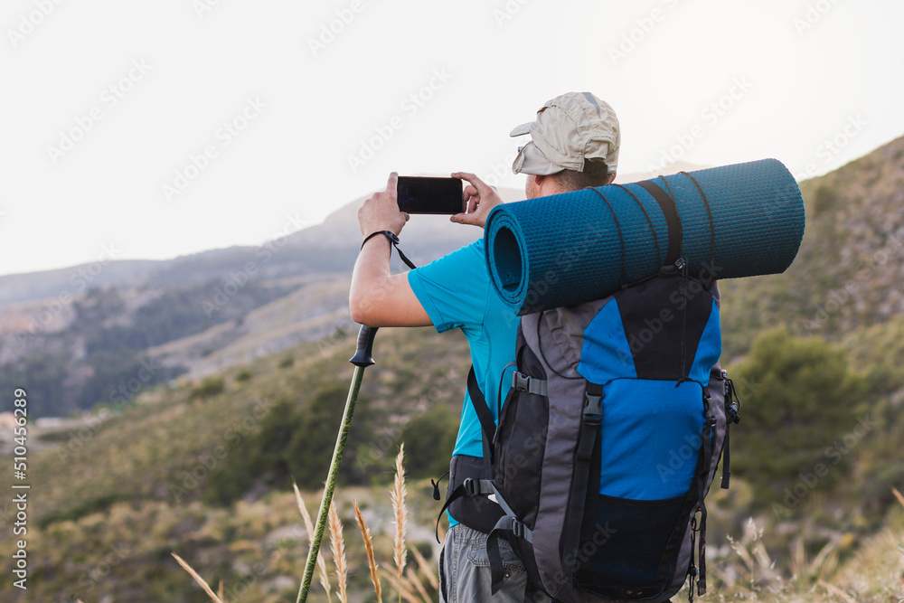 An unrecognizable hiker photographing the scenery