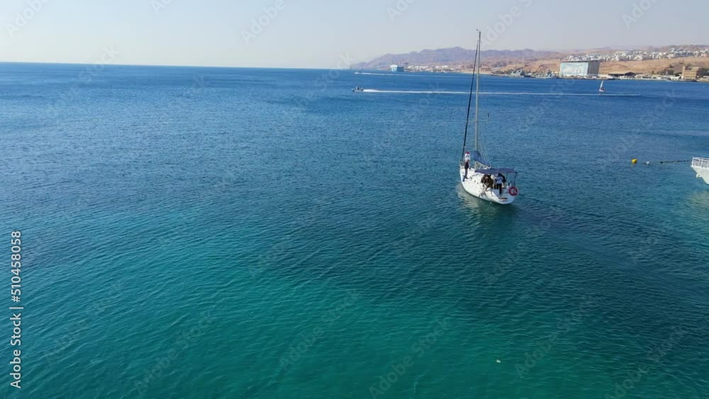 Panning Shot Of Tourists Exploring Red Sea In Yacht During Vacation On Sunny Day - Eilat, Israel Panning Shot Of Tourists Exploring Red Sea In Yacht During Vacation On Sunny Day - Eilat, Israel