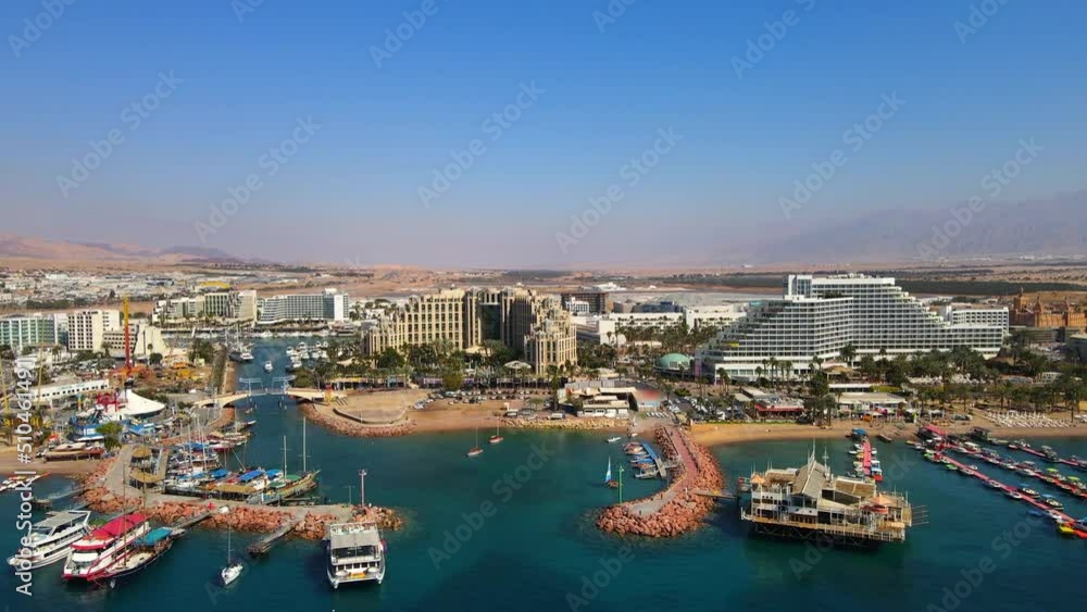 Aerial Descending Shot Of Famous Hotel Buildings In City, Drone Flying Forward Over Sea On Sunny Day - Eilat, Israel Aerial Descending Shot Of Famous Hotel Buildings In City, Drone Flying Forward Over Sea On Sunny Day - Eilat, Israel