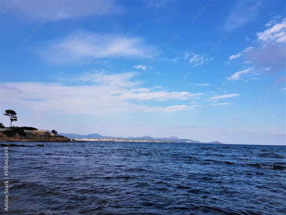 An island in the middle of the sea. A tree on the island. Blue sky. An island in the middle of the sea. A tree on the island. Blue sky.