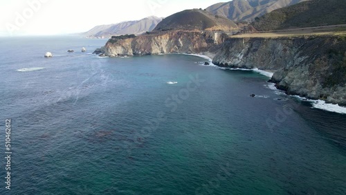 Aerial of the rugged coastline of Big Sur California. The Pacific Coast Highway and the famous Bixby Creek Bridge can be seen.
