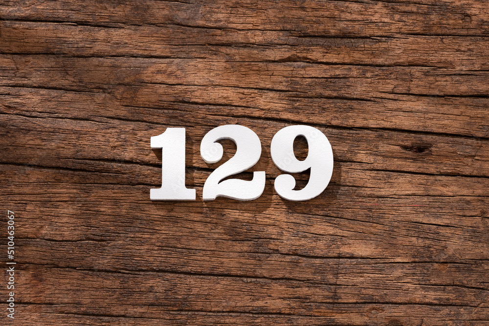 Number 129 in wood, isolated on rustic background Number 129 in wood, isolated on rustic background
