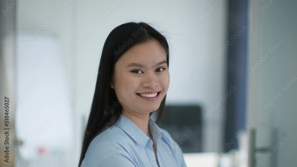 Close up portrait of young positive asian lady employee turning face to camera and laughing, slow motion, free space Close up portrait of young positive asian lady employee turning face to camera and laughing, slow motion, free space