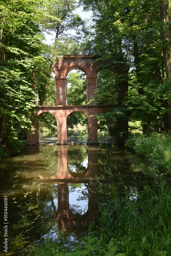 fragment budowli przypominającej akwedukt w starym parku