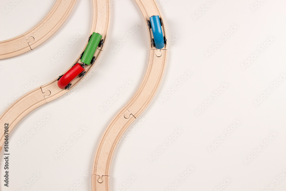 Kid toys background. Wooden toy train on curve wooden railways on white background. Top view, copy space Kid toys background. Wooden toy train on curve wooden railways on white background. Top view, copy space