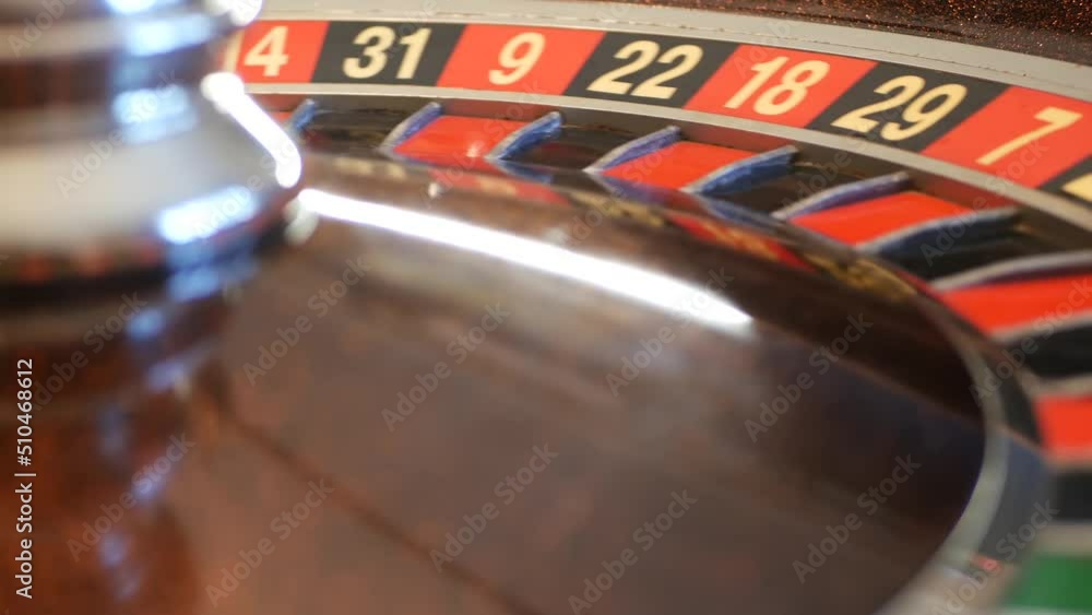 Ball on wooden french roulette table in casino. Wheel spinning, turning or rotating. Odd and even numbers, black, red and zero sectors. Bets in game of chance. Money playing, gambling or risky betting Ball on wooden french roulette table in casino. Wheel spinning, turning or rotating. Odd and even numbers, black, red and zero sectors. Bets in game of chance. Money playing, gambling or risky betting
