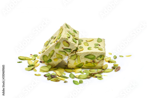 Halva with tahini and pistachio on a white background. Pistachio halva is indispensable for winter months. Tahini, halva, pistachio, sesame.
