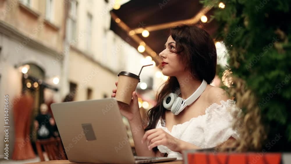 Portrait of attractive woman using laptop and drink coffee in coworking space or cafe. Young woman sitting in front open laptop computer. Study, learning, remote work, freelance. Portrait of attractive woman using laptop and drink coffee in coworking space or cafe. Young woman sitting in front open laptop computer. Study, learning, remote work, freelance.