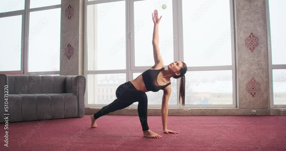 Side view of slim, fit, flexible girl standing with bent legs, raising hand, bending, turning. Beautiful brunette woman stretching, meditating. Concept of yoga and new age. Side view of slim, fit, flexible girl standing with bent legs, raising hand, bending, turning. Beautiful brunette woman stretching, meditating. Concept of yoga and new age.
