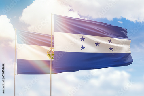 Sunny blue sky and flags of honduras and el salvador