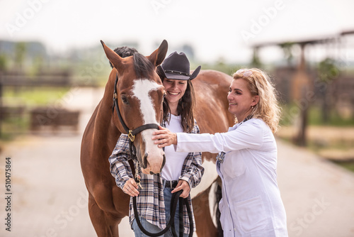 Female vet pets the horse after the examination while the horse cuddles to its owner © weyo