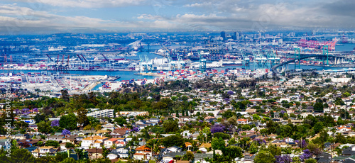 Panorama Long Beach, California skyline and city scape of international port, shipping, cranes, urban homes and surrounding and industrial area.