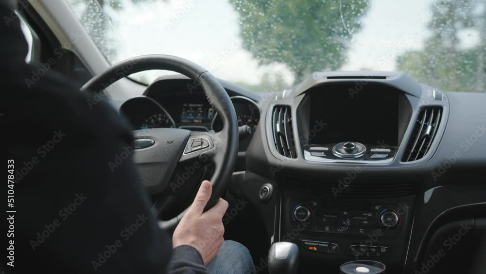 Man drives a car along the road during the rain Man drives a car along the road during the rain