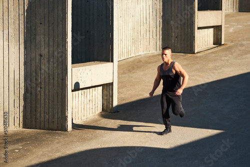 Male athlete running on concrete,