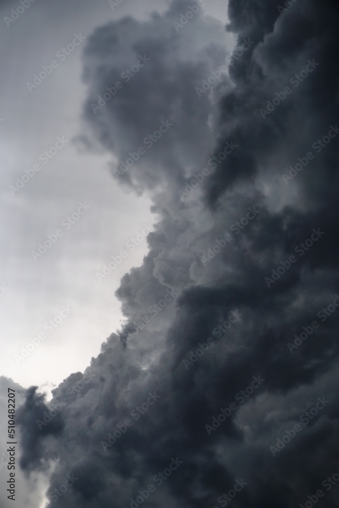 Dark, gloomy, stormy, rainy sky with rays of light. Terrible hurricane clouds. Background image for design