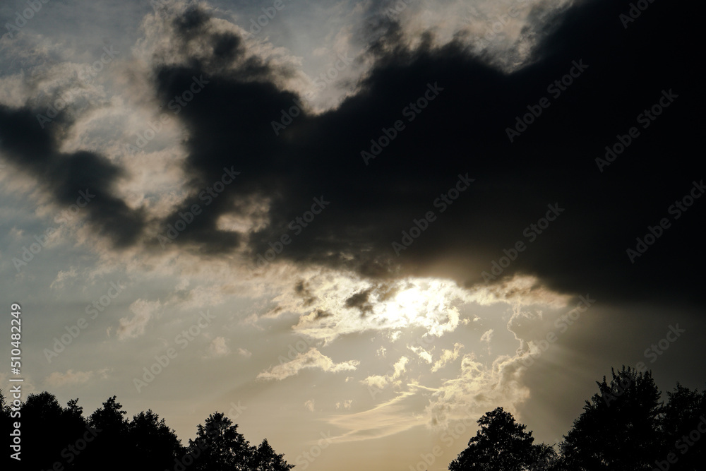 Dark, gloomy, stormy, rainy sky with rays of light. Terrible hurricane clouds. Background image for design Dark, gloomy, stormy, rainy sky with rays of light. Terrible hurricane clouds. Background image for design