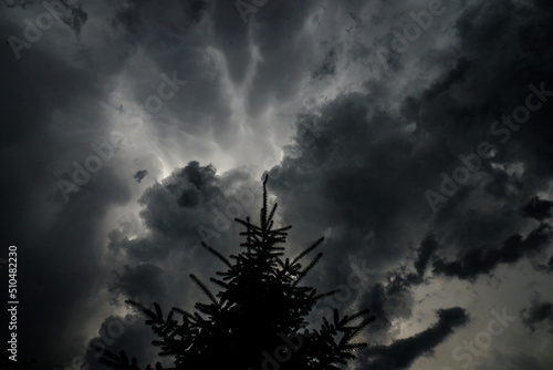 Dark, gloomy, stormy, rainy sky with rays of light. Terrible hurricane clouds. Background image for design