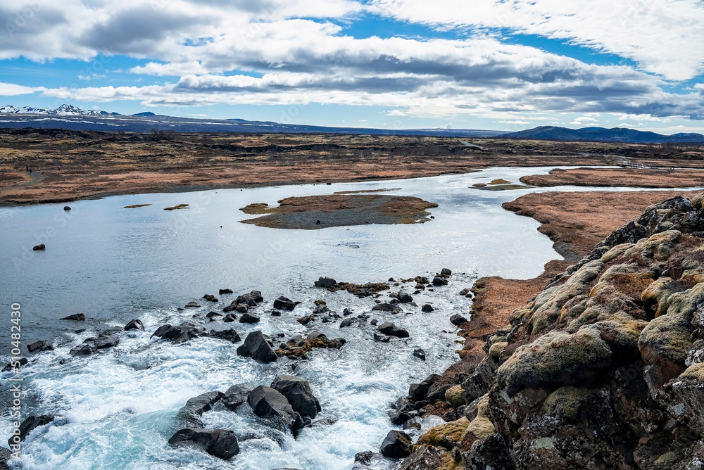 Beautiful view of stream flowing at Drekkingarhylur. Waterfall against cloudy on dramatic landscape. Scenic tourist attraction at Thingvellir National Park.
