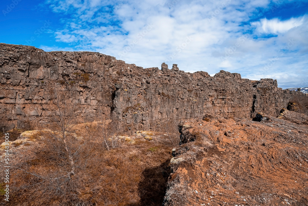 Scenic volcanic rock formations on land against blue sky. View of beautiful dramatic landscape and mountains. Concept of picturesque natural environment in Alpine region.