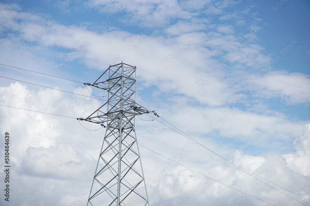 Large electric poles in the field against the blue sky. High voltage power lines. Large electric poles in the field against the blue sky. High voltage power lines.