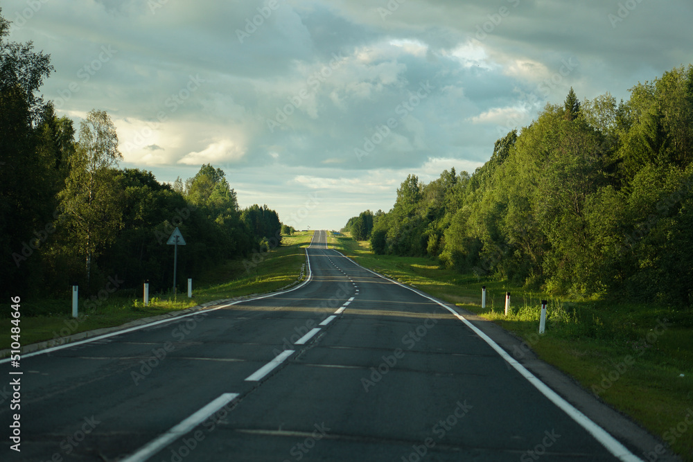 Empty highway through the forest. Beautiful summer landscape background. Travel Empty highway through the forest. Beautiful summer landscape background. Travel