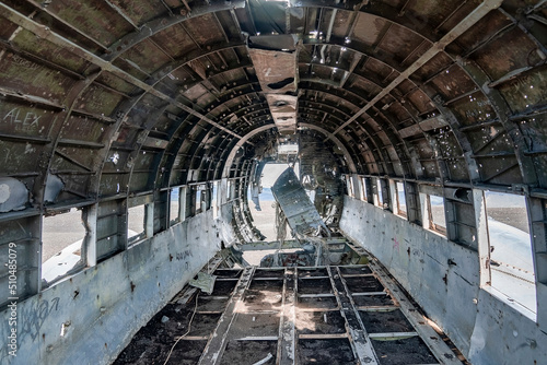 Interior of crashed military airplane wreck. Abandoned broken metallic aircraft at black sand beach. Famous tourist attraction in Solheimasandur on volcanic landscape.
