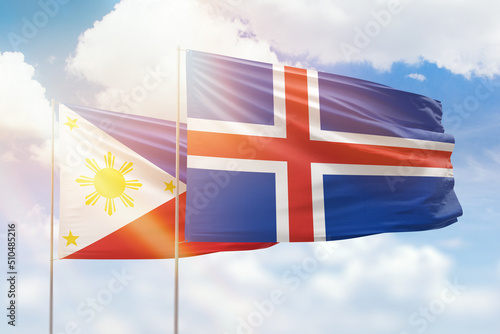 Sunny blue sky and flags of iceland and philippines