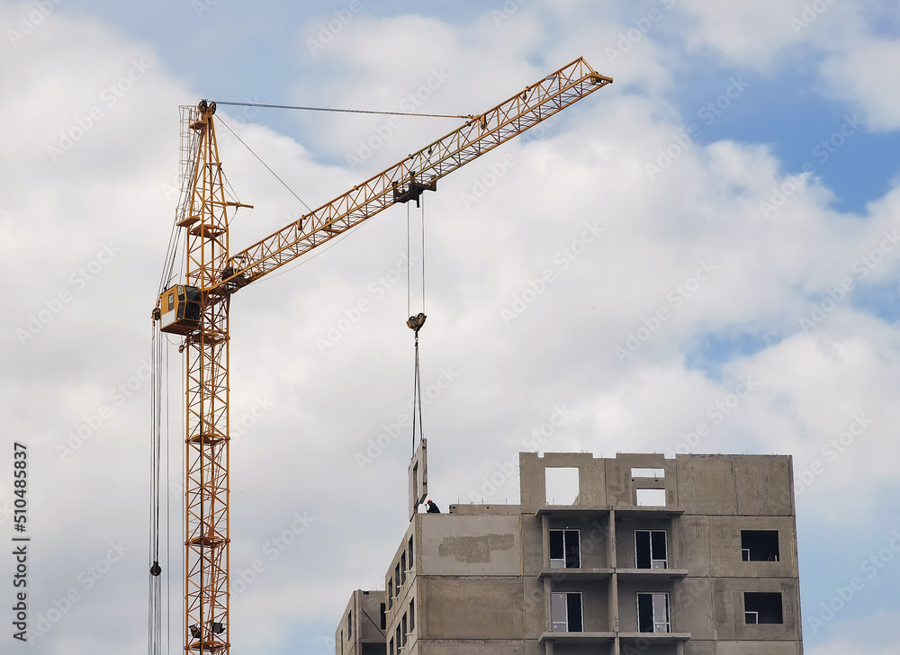 Crane and unfinished house. Building construction. A Crane is pulling a detail of a house. Crane and unfinished house. Building construction. A Crane is pulling a detail of a house.