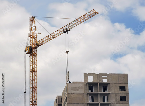 Crane and unfinished house. Building construction. A Crane is pulling a detail of a house.