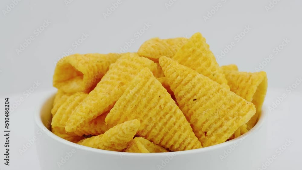 Close-up Crunchy corn snacks on a white bowl. Top view.