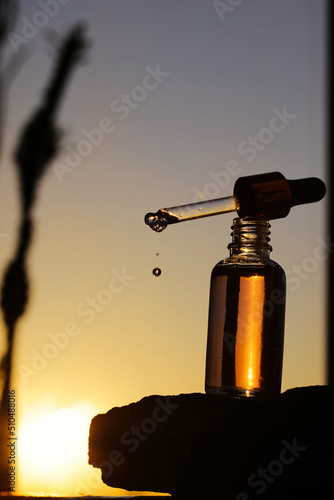 serum in a glass bottle on a natural background. essential oil for skin care 
