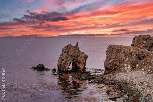 Scenic view of rock formations at seashore. Beautiful view of seascape against dramatic sky. Idyllic scenery of Atlantic ocean in northern Alpine region during sunset.