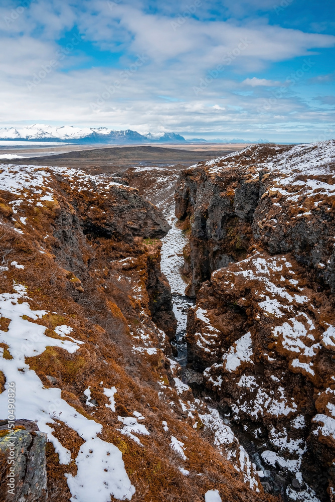Obraz premium High angle view of snow covered mountains. Scenic view of icecap rock formations in volcanic valley against sky. Beautiful scenery of Icelandic winter landscape.