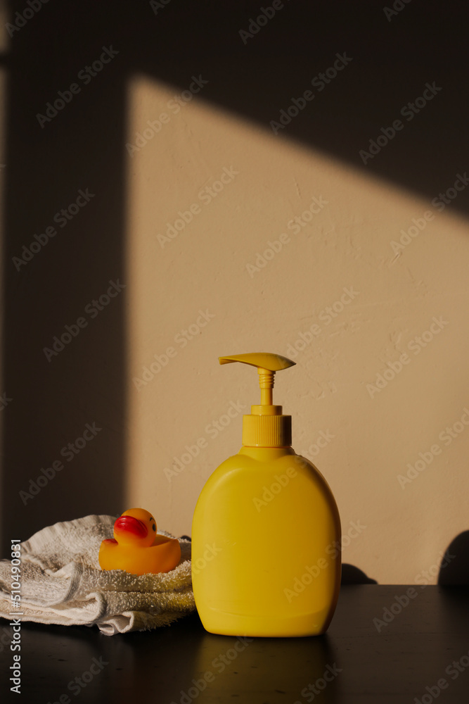 Soap or shampoo bottles with cute duck on yellow background. Baby bathing accessories Soap or shampoo bottles with cute duck on yellow background. Baby bathing accessories