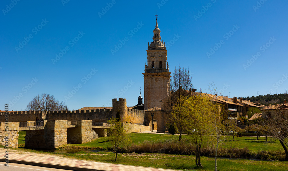 Burgo de Osma Cathedral, Soria, Spain. Landscape under blue sky in afternoon with view of bridge across Ucero river.