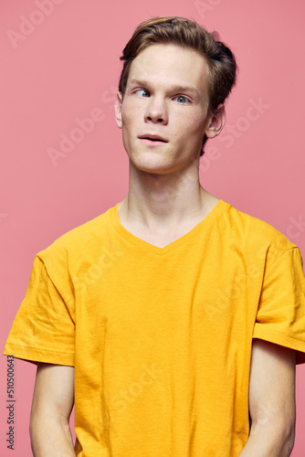 funny guy makes faces while standing on a pink background