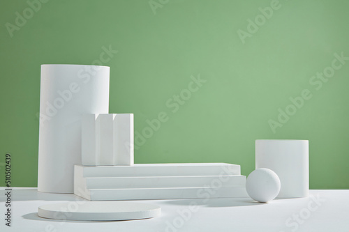 Front view of white podium and stairway with blank space in green background abstract content