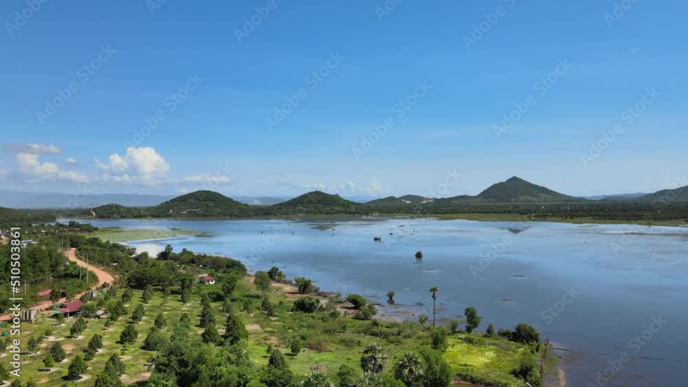 aerial drone shot of a large lake surrounded surrounded by mountains on a sunny day aerial drone shot of a large lake surrounded surrounded by mountains on a sunny day