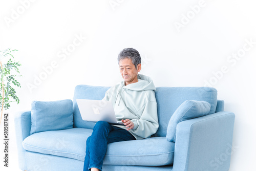 自宅でパソコンを使う高齢の男性
